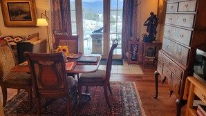 Una sala de estar acogedora con una mesa de comedor de madera, sillas, un sofá y un mueble para televisión.