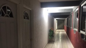 A corridor with tiled flooring, white doors, and a plant. - Hotel Siesta (Ixtaczoquitlán)