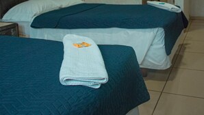A hotel room with two beds, a dark headboard, a white air conditioning unit, and a bathroom visible through an open door. - Hotel Siesta (Ixtaczoquitlán)