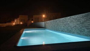 A swimming pool with a stone wall and a staircase leading to a building. - Monte do Mosteiro CountryHouse (Batalha)