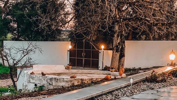 A pathway leading to a building with a gated entrance, surrounded by trees and decorative lighting. - Monte do Mosteiro CountryHouse (Batalha)