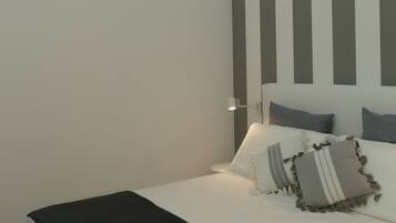 Un dormitorio moderno con una cama, una lámpara de noche y una lámpara de techo original.