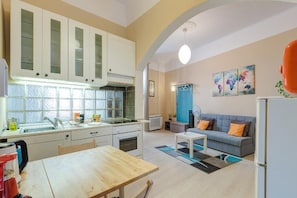 Un espacio habitable compacto con kitchenette, comedor y zona de estar.