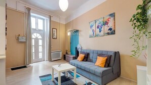 A modern living room with a grey sofa, a white coffee table, and a world map artwork on the wall.