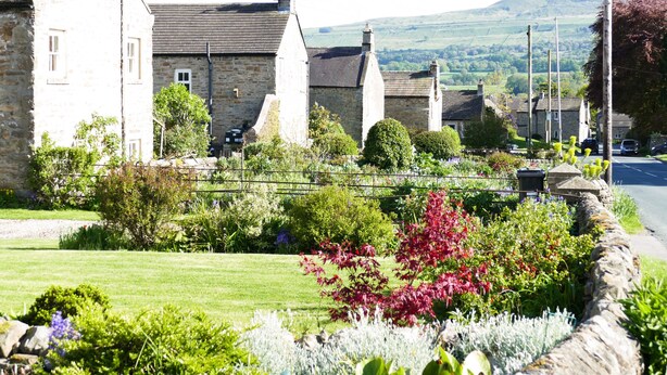 A stone building with a traditional design, surrounded by a well-maintained garden with various plants and flowers. - 2 bedroom accommodation in Redmire, near Leyburn (Redmire, near Leyburn)