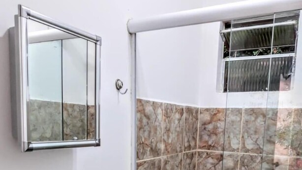 Une salle de bain avec un lavabo, un miroir et des murs carrelés.
