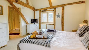 A bedroom with a wooden ceiling, a bed with a white comforter, a bedside table with a lamp, a window with blinds, and a star decoration on the wall. - 3 bedroom accommodation in Tacolneston, near Wymondham (Tacolneston, near Wymondham)