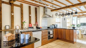 A modern kitchen with wooden beams, a central island, and a built-in oven. - 3 bedroom accommodation in Tacolneston, near Wymondham (Tacolneston, near Wymondham)