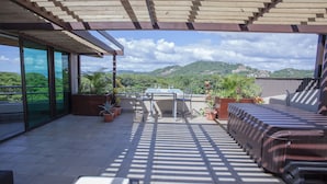 A covered patio with a table and chairs, potted plants, and a hot tub. - El Cubil 8 (Sardinal)