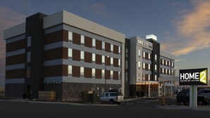 Un immeuble hôtelier à plusieurs étages, sur lequel on peut lire l’inscription « HOME 2 SUITES BY HILTON ».