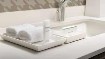 Un lavabo de salle de bain avec une serviette blanche et un flacon de lotion pour le corps de la marque Neutrogena.