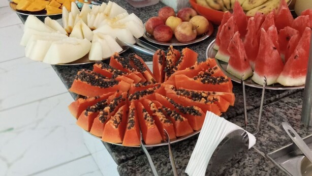 Un bufé con diferentes frutas y aperitivos.