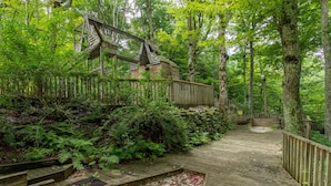 A wooden boardwalk leading through a forested area with a wooden structure on the left. - Hearthstone- AppSki Mtn home with it all: hot tub, game room, fire pit, pets! (Blowing Rock)