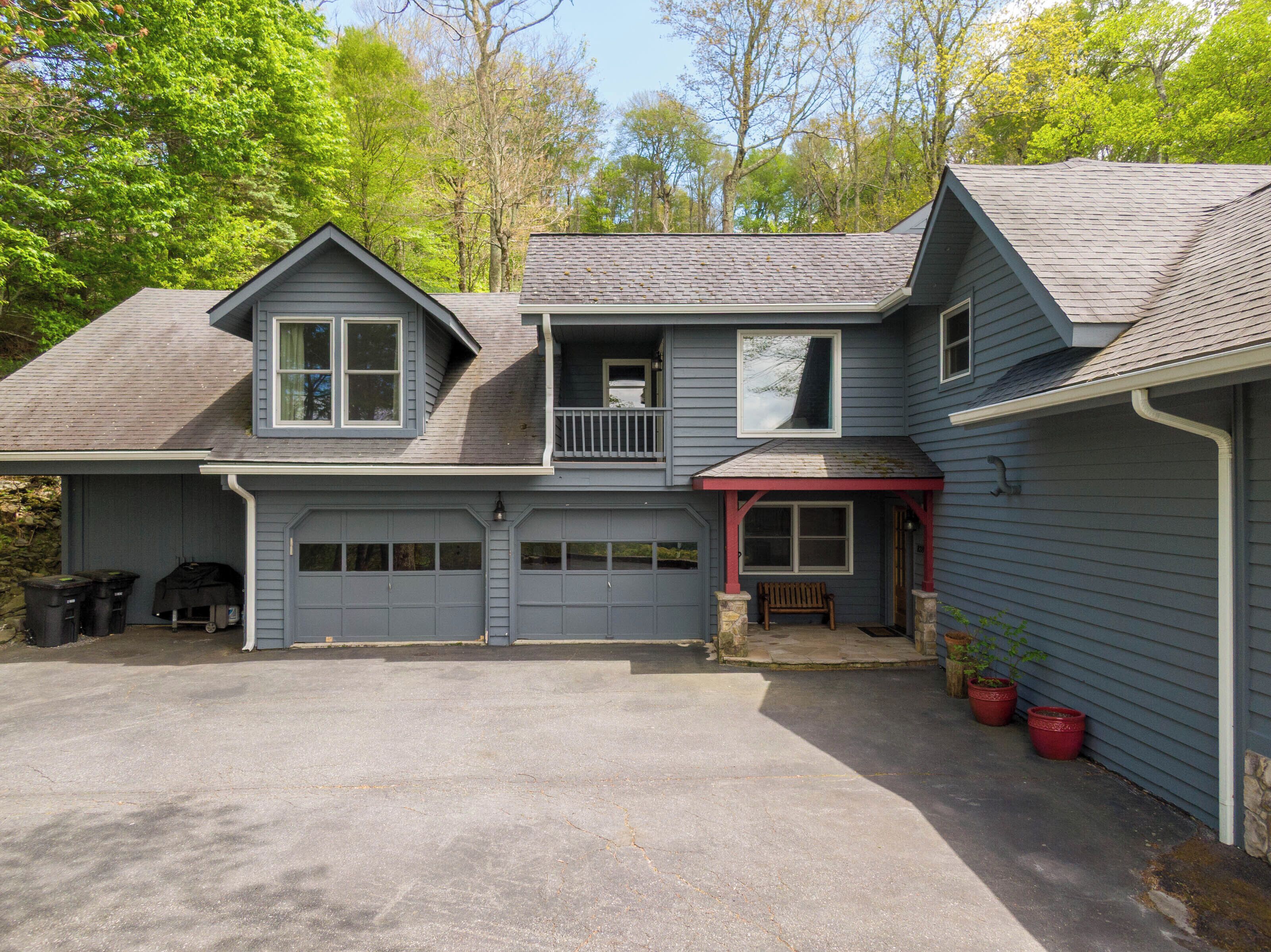 A two-story house with a garage, a covered porch, and a small deck.