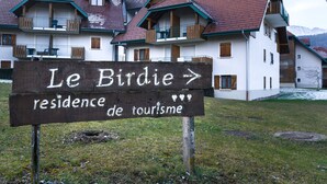 A wooden sign with text indicating 'Le Birdie residence de tourisme' and a directional arrow. - The green fee, close to the Golf course and 5 minutes from the lake (Giez)