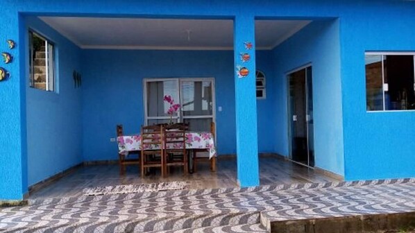 A blue room with a dining table and chairs, a window, and a door.