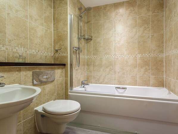 A bathroom with a bathtub, toilet, and sink.