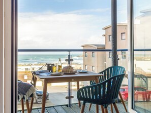 A balcony with a table, chairs, and a view of the ocean. - 2 bedroom accommodation in Newquay (Newquay)
