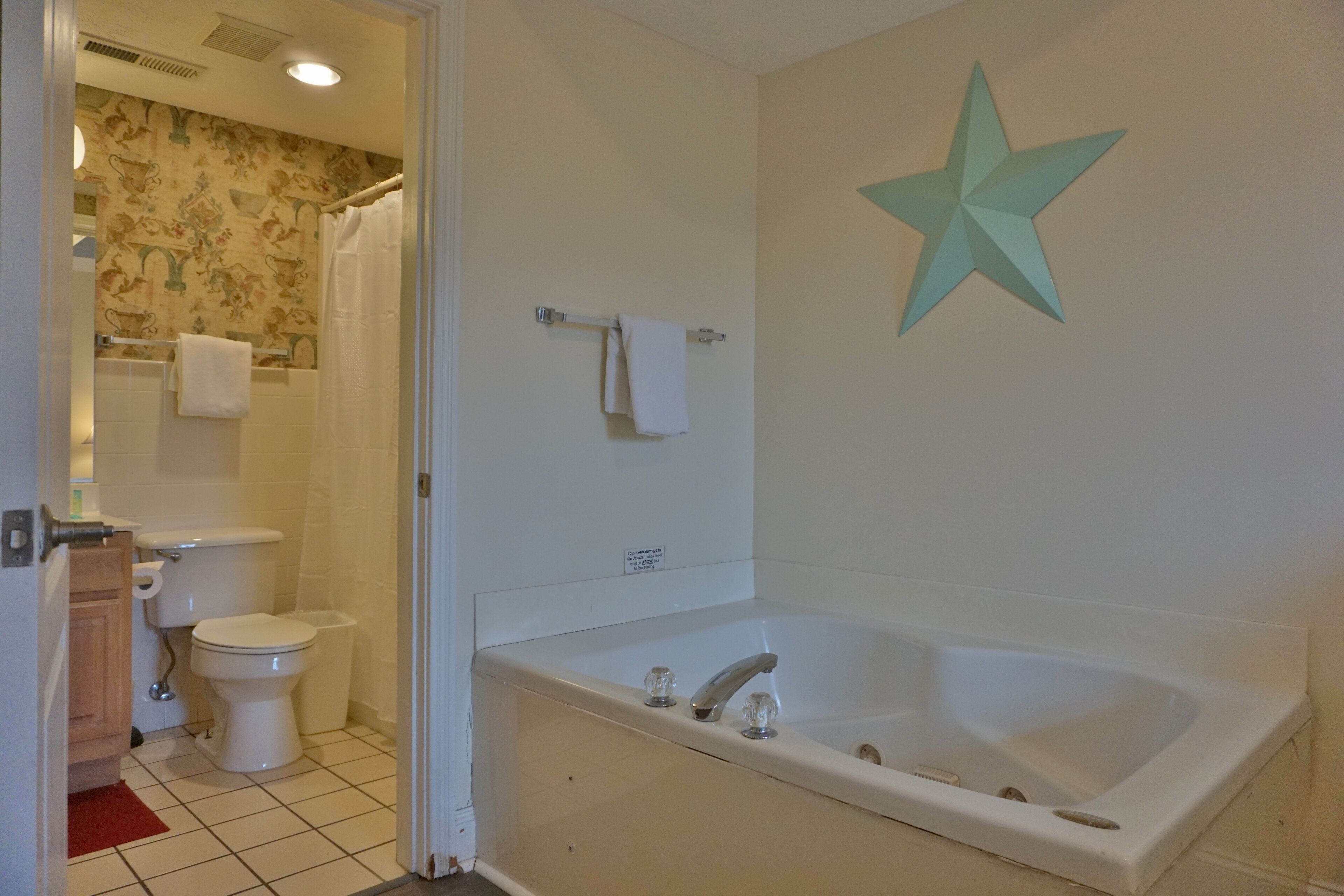 Une salle de bain équipée de toilettes, d’une baignoire et d’un rideau de douche.