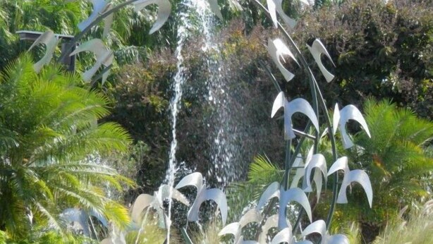 A garden with a central water feature and abstract metal sculptures. - Paradise Haven in Palmas del Mar, a charming house for the perfect vacations! (Humacao)