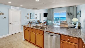 A kitchen with granite countertops, wooden cabinets, and a stainless steel dishwasher.