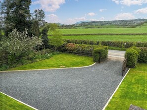 A gravel driveway leading to a property with a green lawn and a stone wall. - What more could you ask for than a spacious family home in a rural haven. (Yanwath, near Penrith)