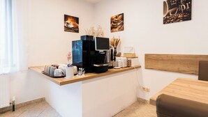 Una cocina moderna con estación de café, cabecero de madera y obras de arte en las paredes.