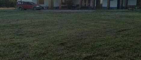 Un edificio de techo plano con un amplio espacio verde frente a él.