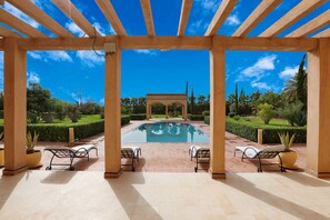 A covered outdoor area with a pool, lounge chairs, and a pergola structure. - Atlas Widan (Marrakech)