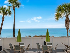 Relax on the ocean-view deck with comfortable seating and shade from the umbrellas.