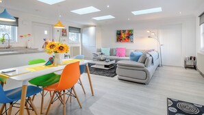 A modern living space with a dining area, sofa, and artwork. - 2 bedroom accommodation in Caldercruix, near Airdrie (Caldercruix, near Airdrie)