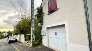 A building with a garage door, a utility pole, and a sign that reads 'J&J ROOM'. - J&J Room - Exceptional accommodation near Provins. www.jj-accommodation.fr (Saint-Loup-de-Naud)