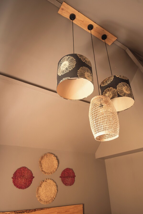 Un plafond orné de trois lampes suspendues et de quatre éléments décoratifs fixés au mur.