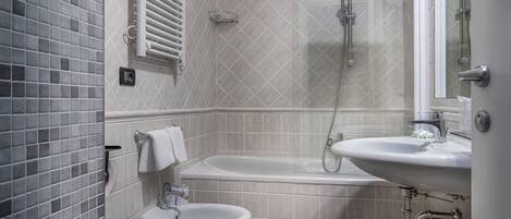 A modern bathroom with a bathtub, a sink, and a bidet.
