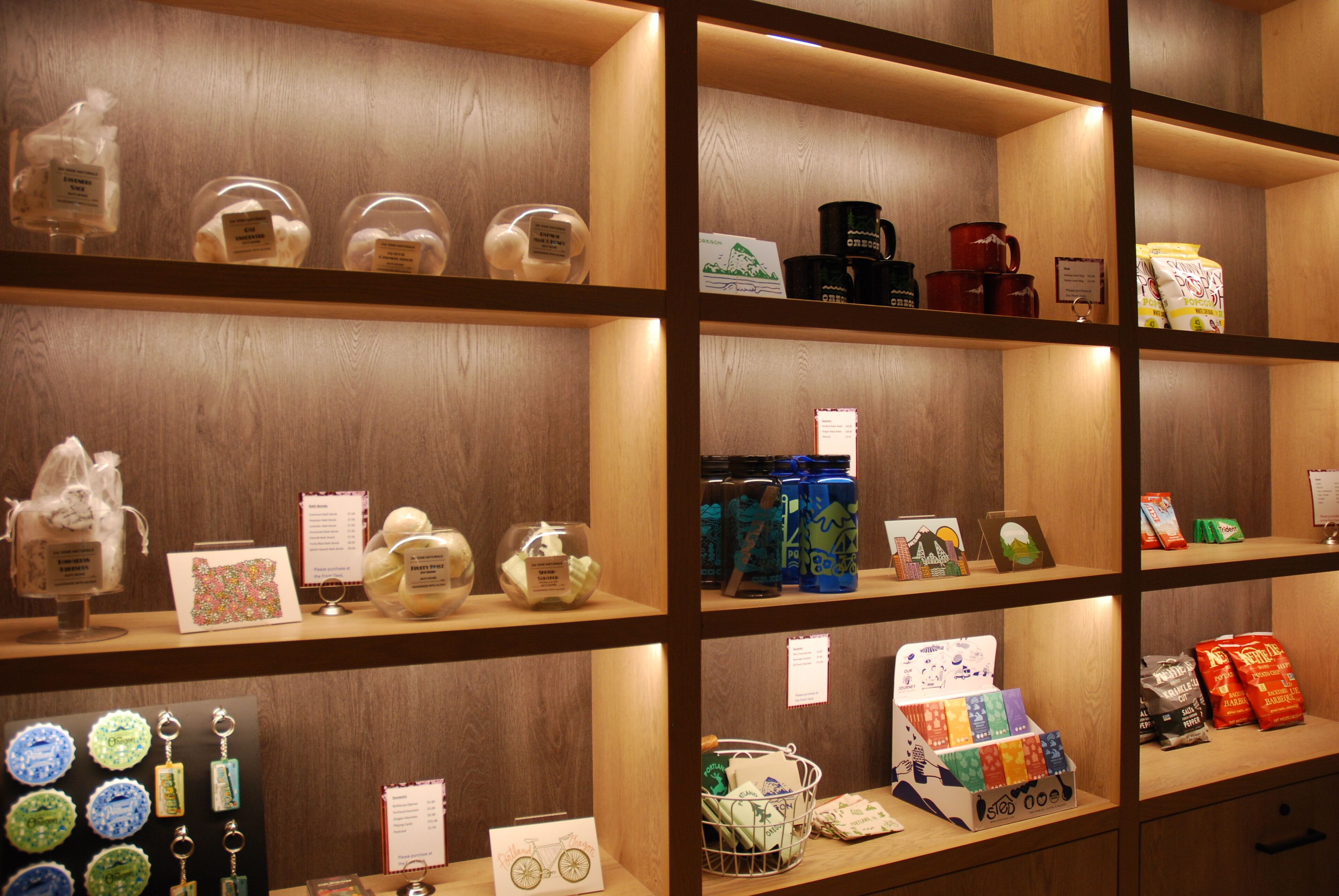 A display of various items on wooden shelves, including jars, mugs, and packaged goods.