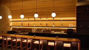 A bar area with wooden chairs and a long counter. - Cedartree Hotel Portland Hillsboro (Hillsboro)