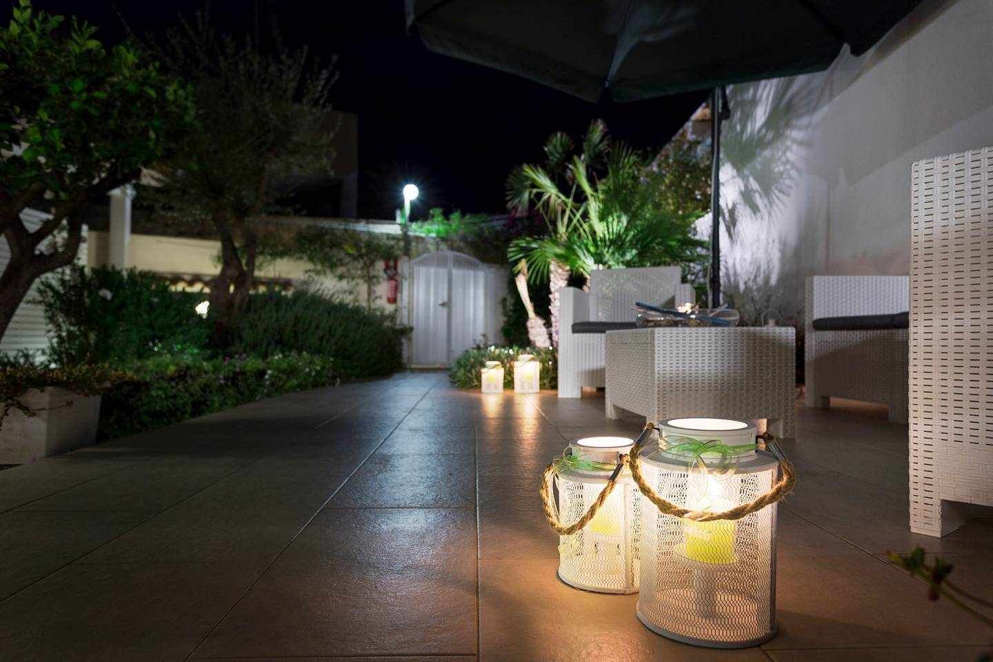 An outdoor patio area with wicker furniture and decorative lanterns.