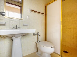 A bathroom with a sink, toilet, and a mirror.