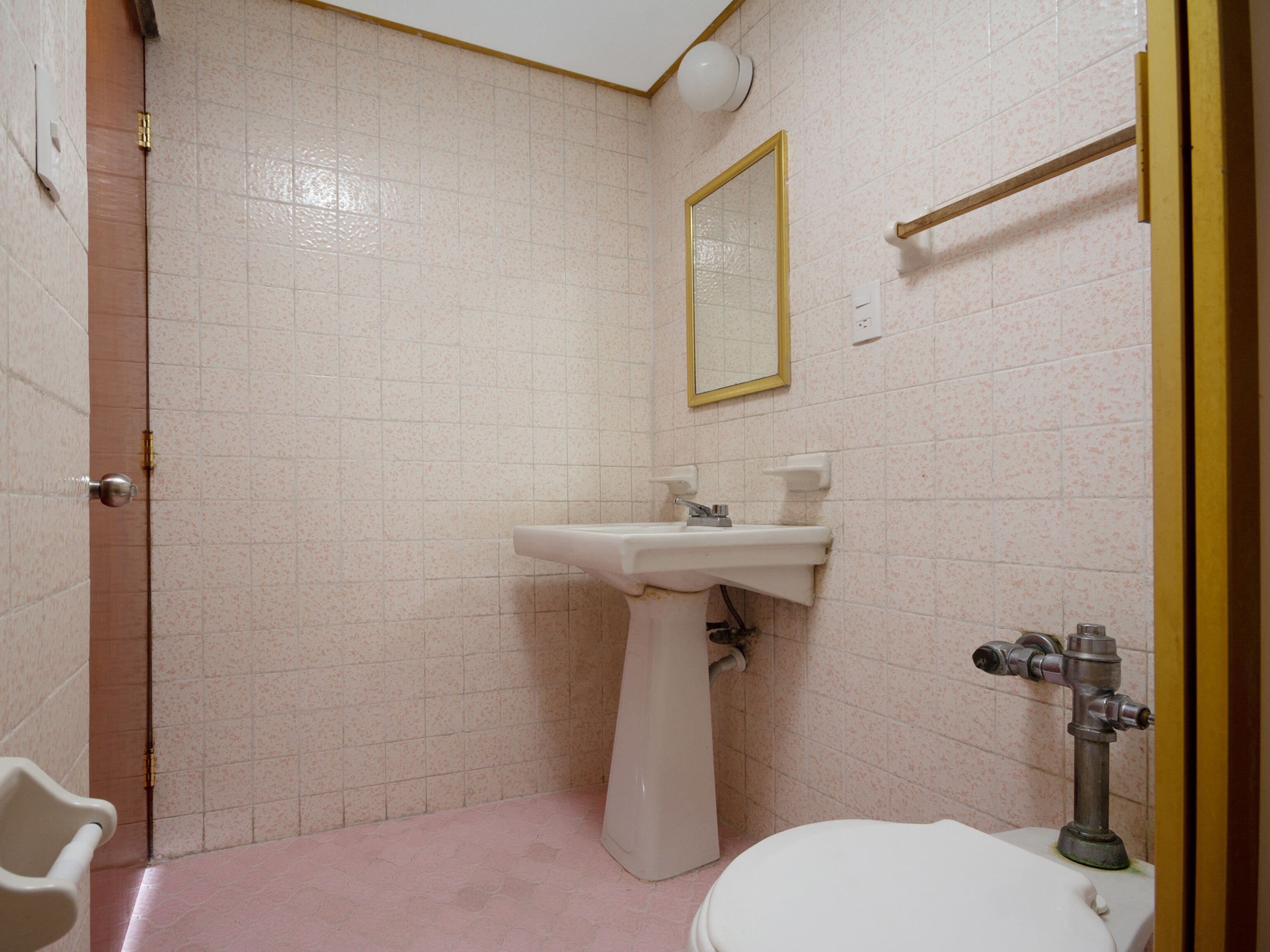 A bathroom with a white sink, a mirror, and a toilet.