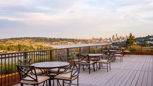 Une terrasse avec des sièges extérieurs donnant sur un paysage urbain.