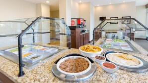 A buffet area with various food options, including a meat dish, chips, and tortillas. - Queen Studio Near Downtown | Breakfast + Pool Access! (Seattle)