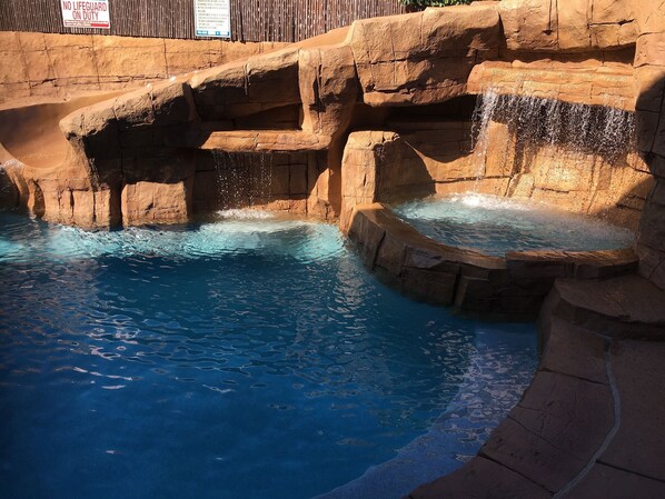 A pool with clear blue water, rocky edges, and a sign indicating no lifeguard on duty. - 2.7MI DISNEY//CONVENTION CENTER GETAWAY (Anaheim)