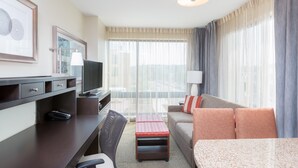 A hotel room with a desk, television, sofa, and a dining table. - King Suite Near Downtown | Breakfast + Pool Access! (Seattle)