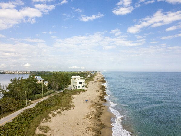 Situated on a sandy beach, this property offers a two-story building with a flat roof and a balcony overlooking the ocean.