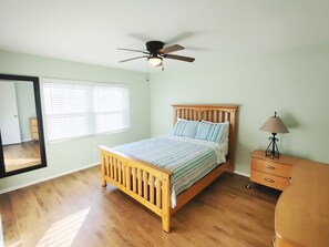Cozy bedroom with a comfortable bed, bedside table, and ceiling fan.