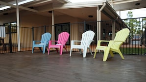 A covered outdoor area with a wooden deck and a railing. - Weipa Motel Resort (Rocky Point)