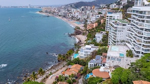 Un paisaje urbano costero con playa, edificios modernos y una vista despejada del océano.