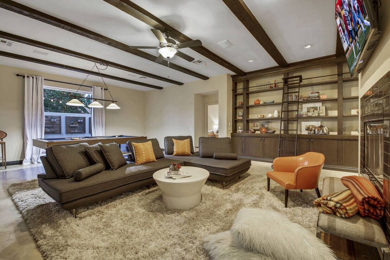 A modern living room with a sectional sofa, a coffee table, and a fireplace.