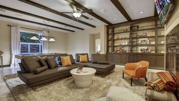 A modern living room with a sectional sofa, a coffee table, and a fireplace.