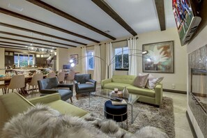 Una sala moderna con un sofá, sillas, una mesa de centro y una chimenea.